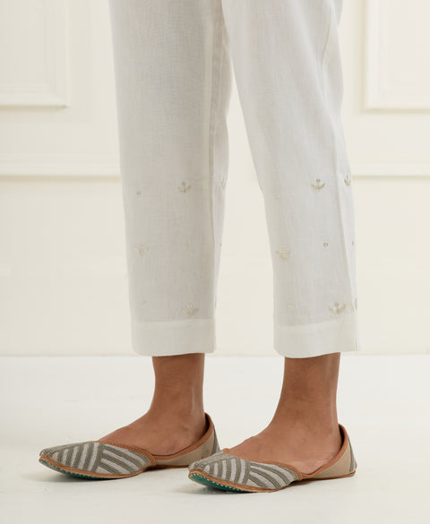 Off-white chanderi cotton flax pants in a slim fit with silver pittan embroidered booti