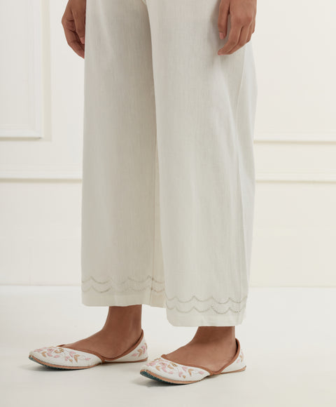 Pink linen top with intricate thread and pittan embroidery paired with offwhite straight fit embroidered cotton pants